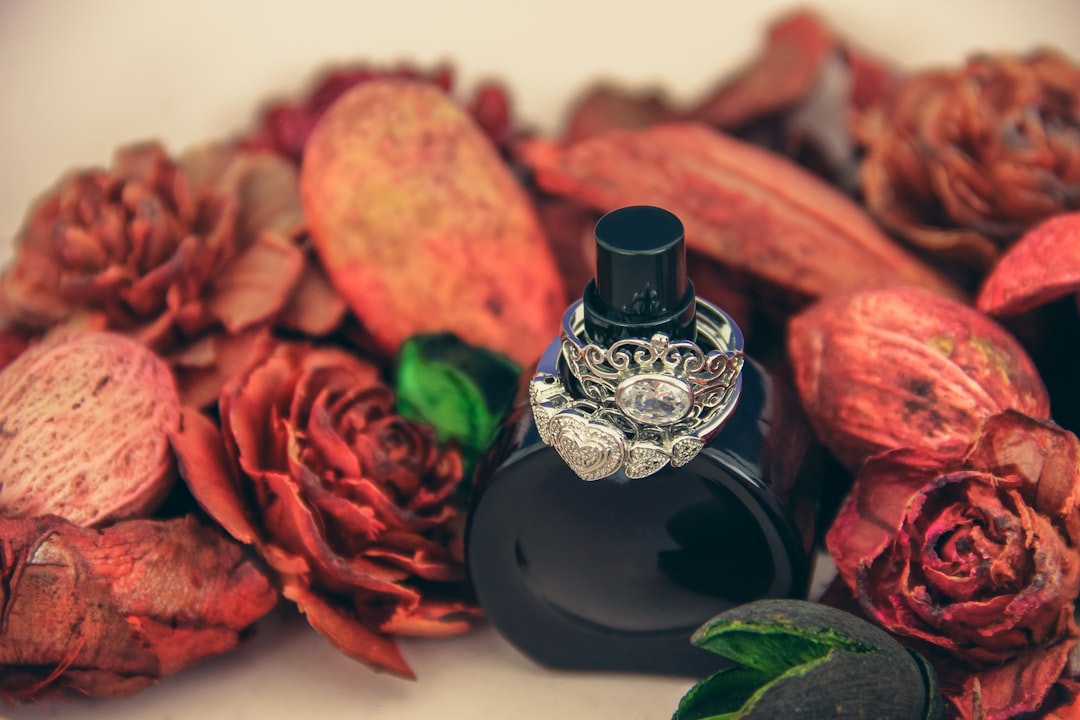 An amber-toned perfume bottle beside dried botanicals