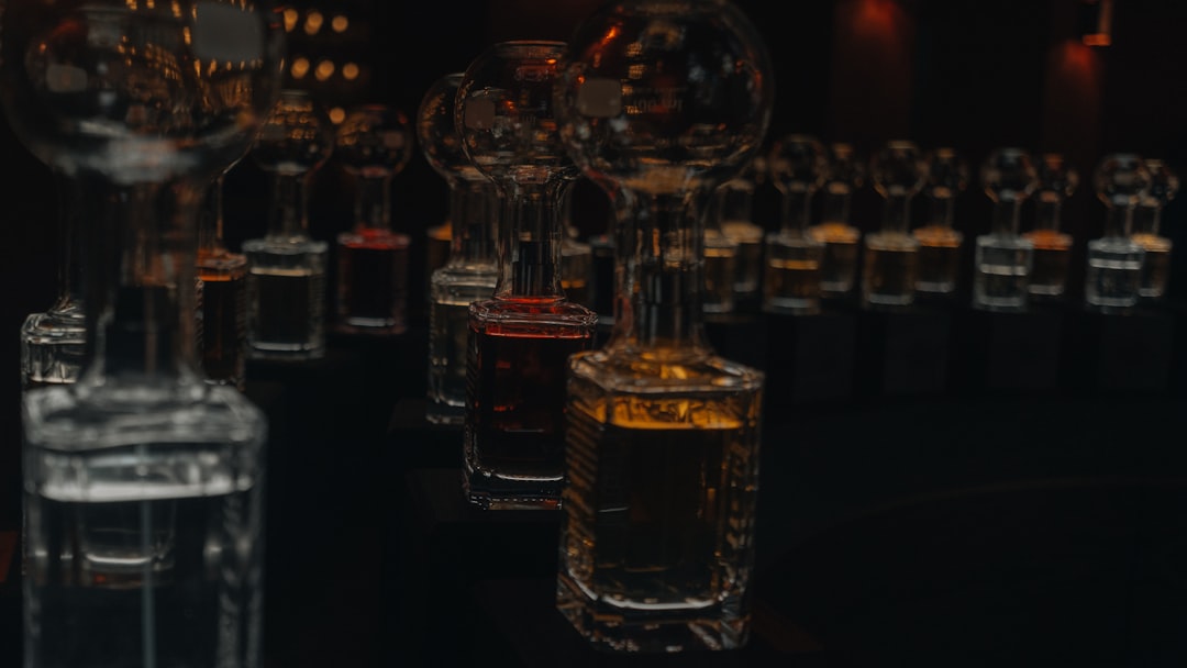 A row of clear perfume bottles arranged on a neutral surface